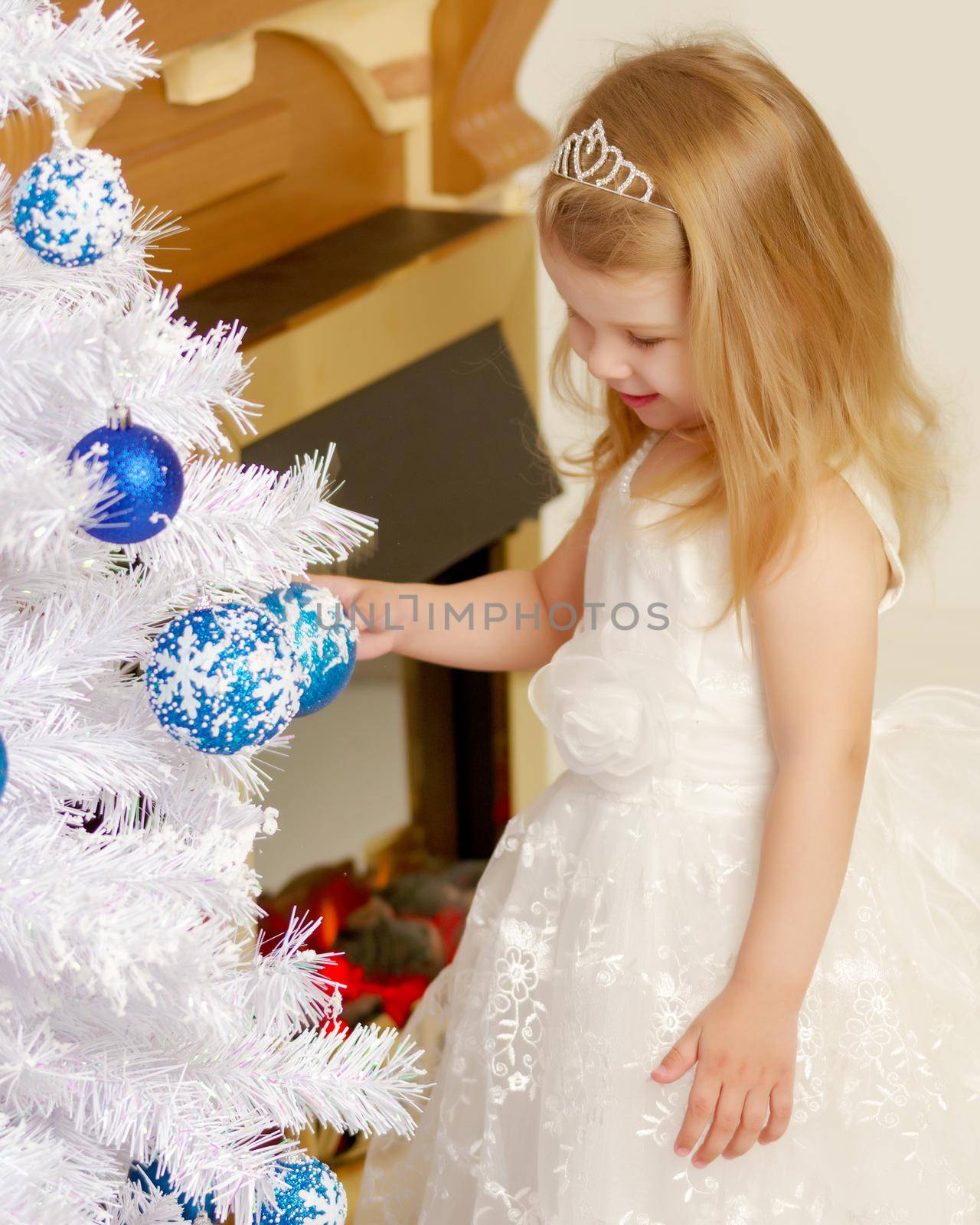 Cute little girl in the new year near the fireplace. Family holidays concept.