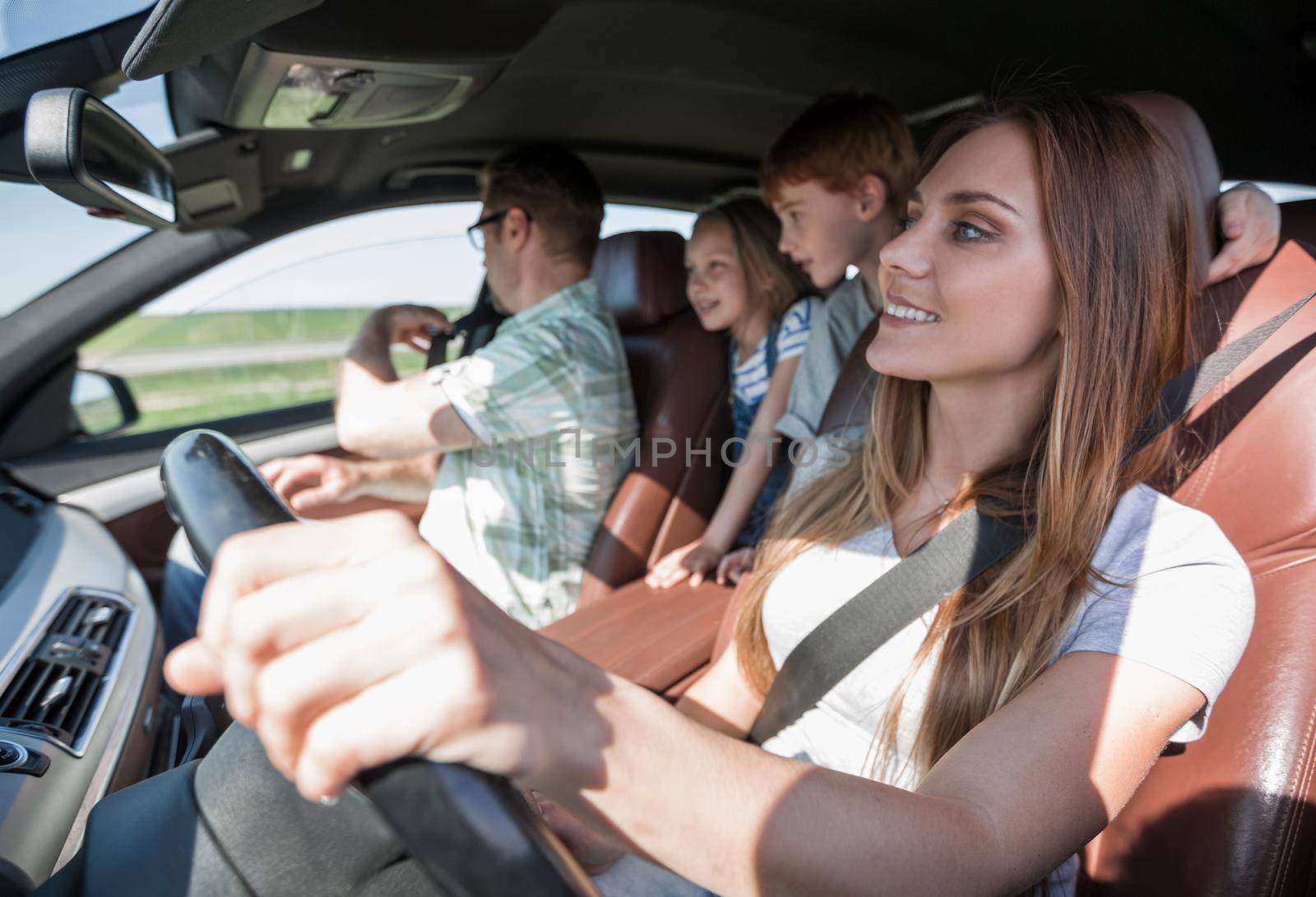 happy mom driving a family car by asdf