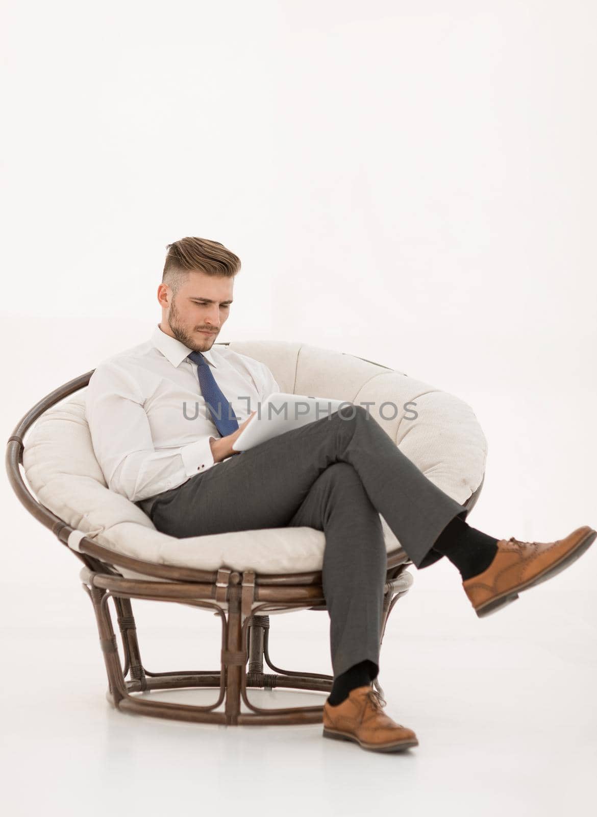 successful businessman using a digital tablet, sitting in a chair.photo with copy space