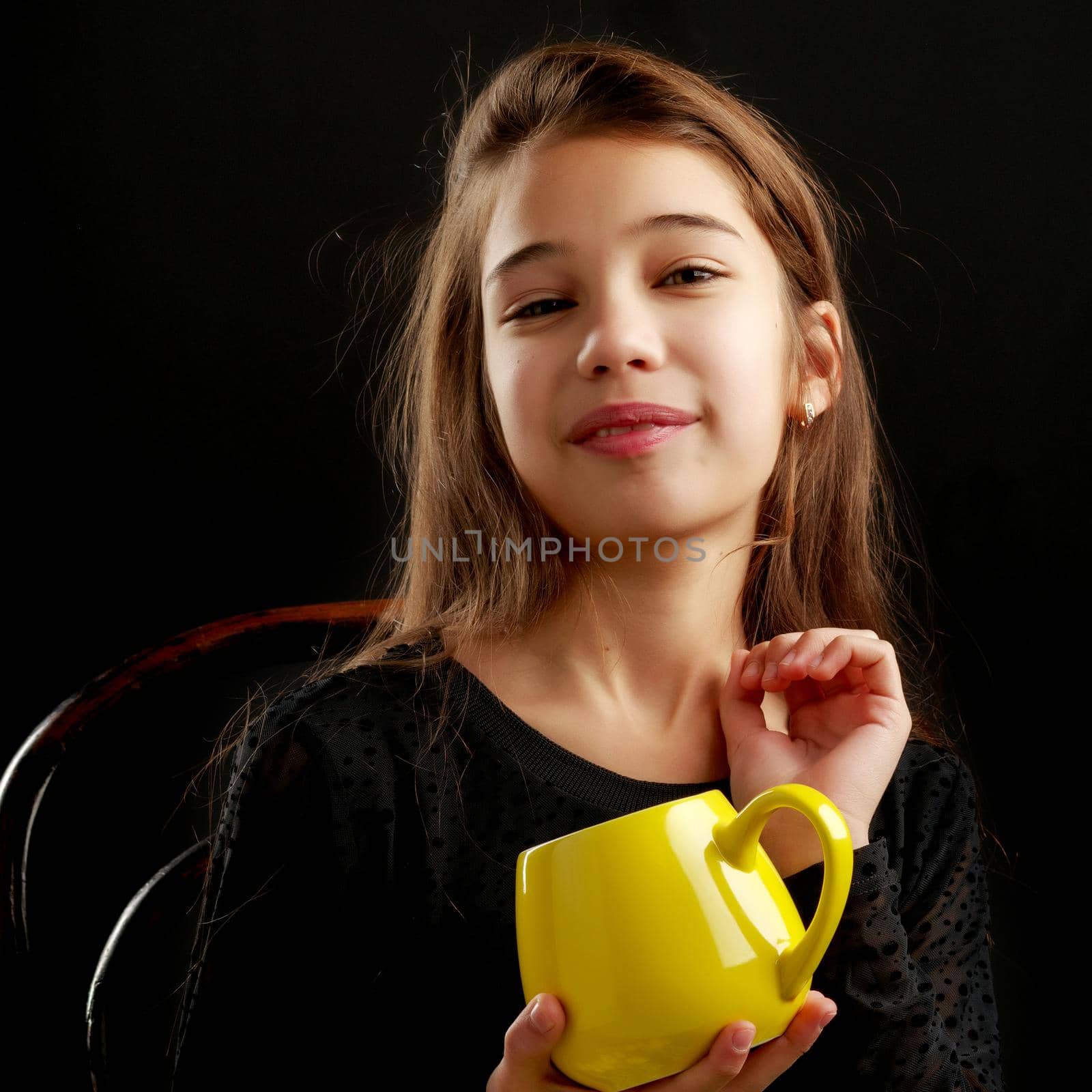Little girl with a mug on a black background. by kolesnikov_studio