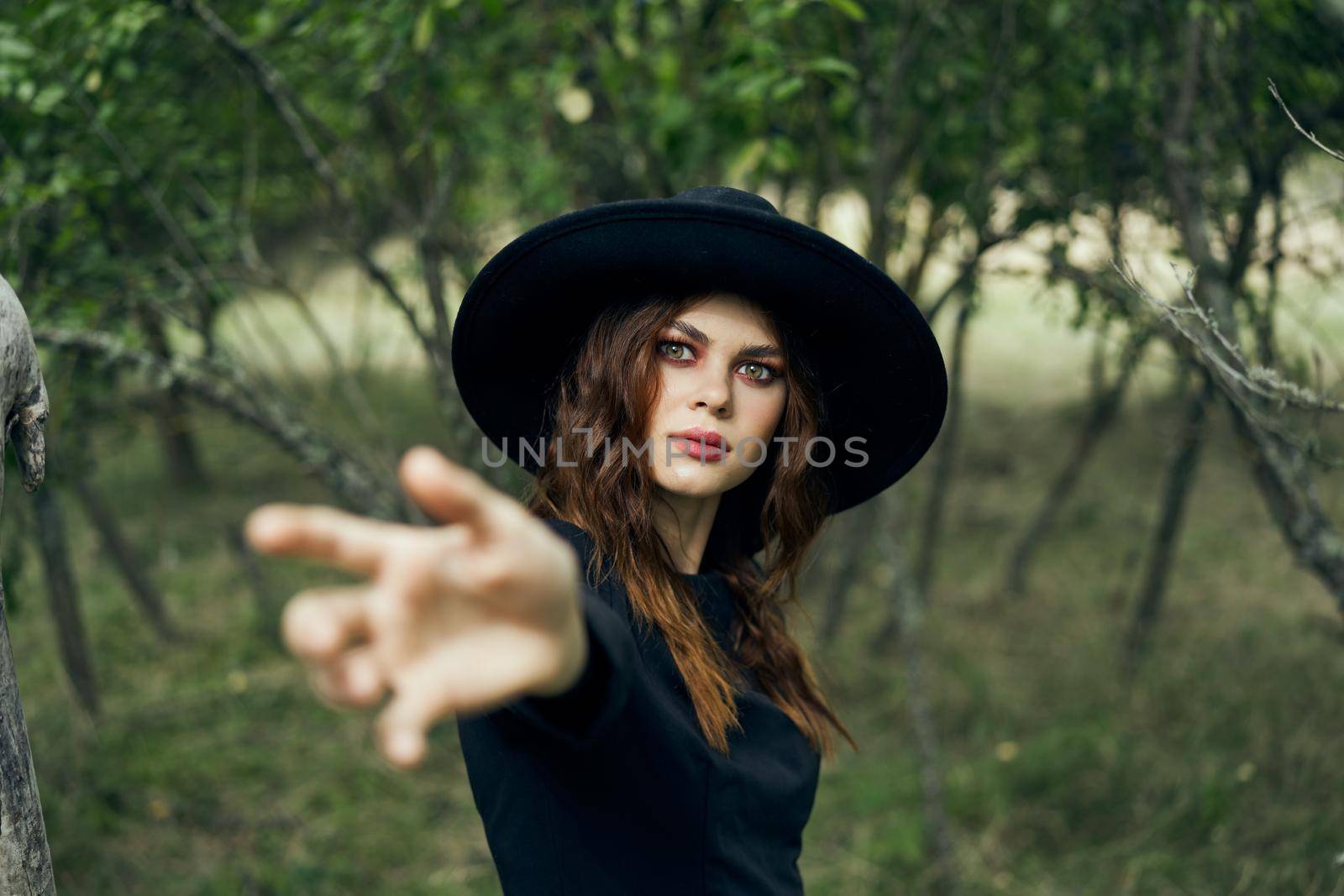woman in a black hat gesturing with her hands witch magic fantasy by Vichizh