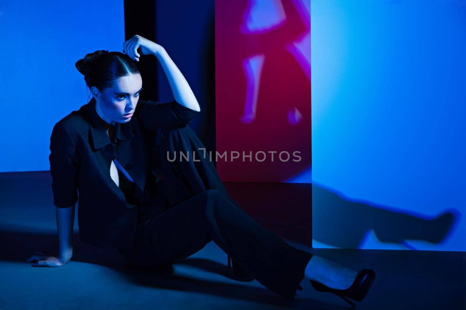 Fashion Portrait of beautiful woman wearing luxury suit and posing over colorful background
