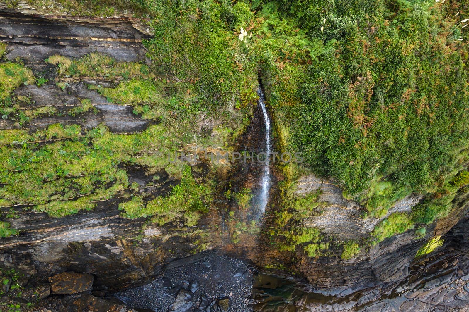 Aerial view of an idyllic waterfall at tropical coastline scenery. High quality photo.