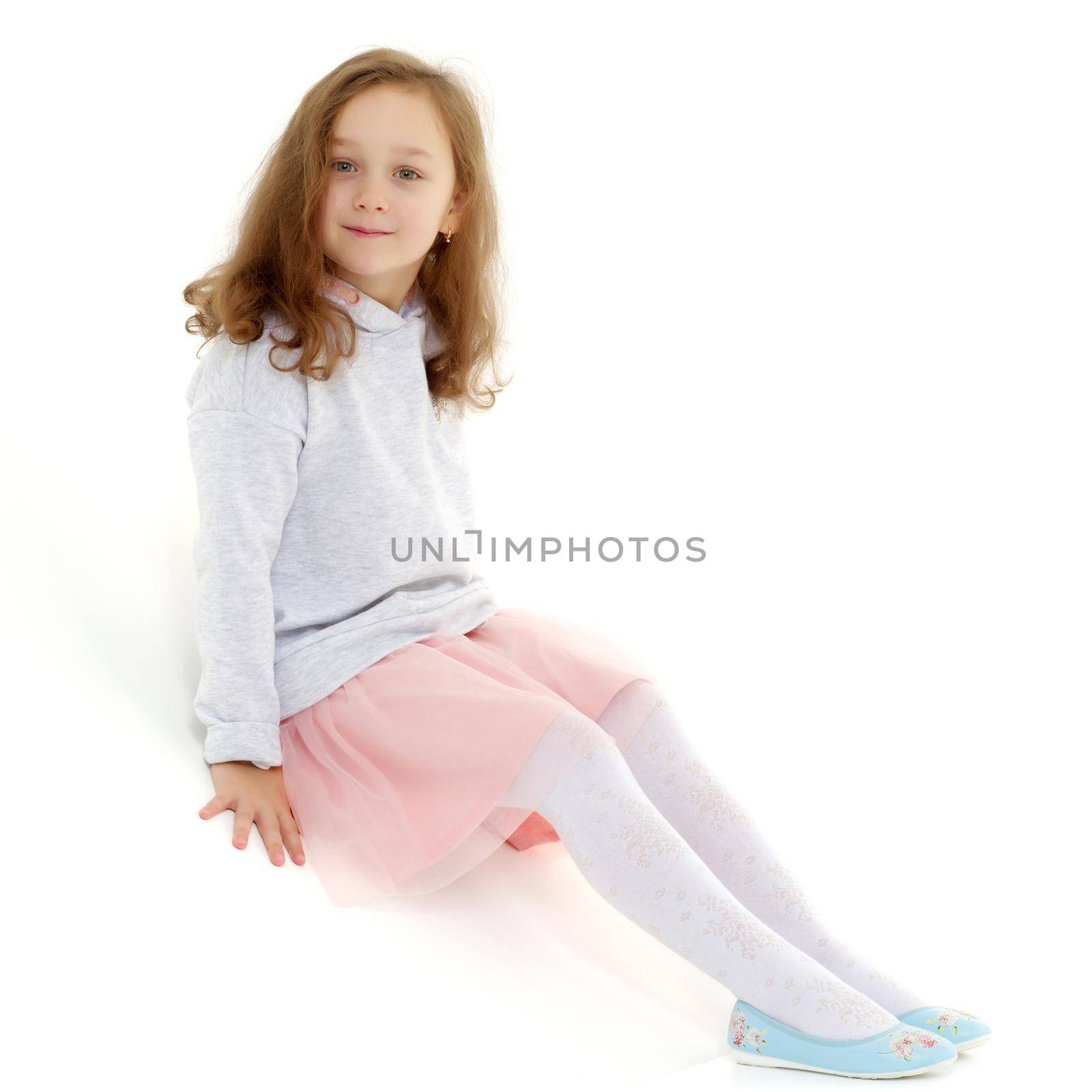 Cute little girl playing in the studio on the hill. Cyclorama. Isolated on white background.