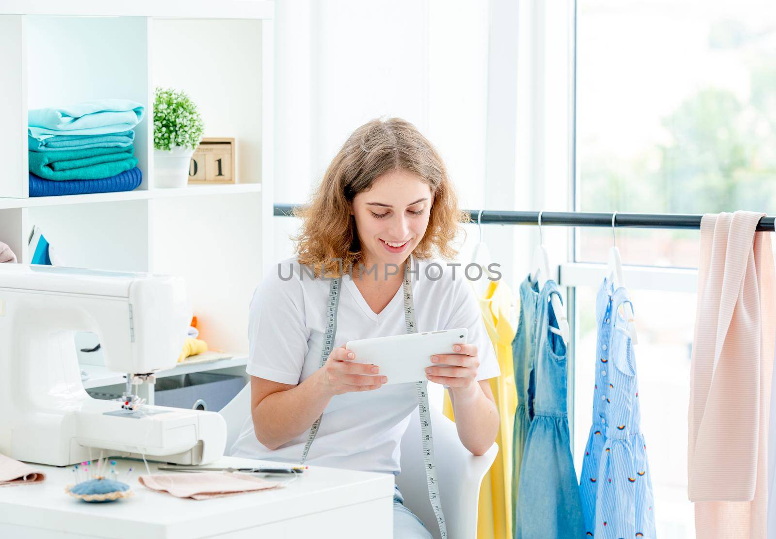 Dressmaker selecting sketch on tablet at workshop