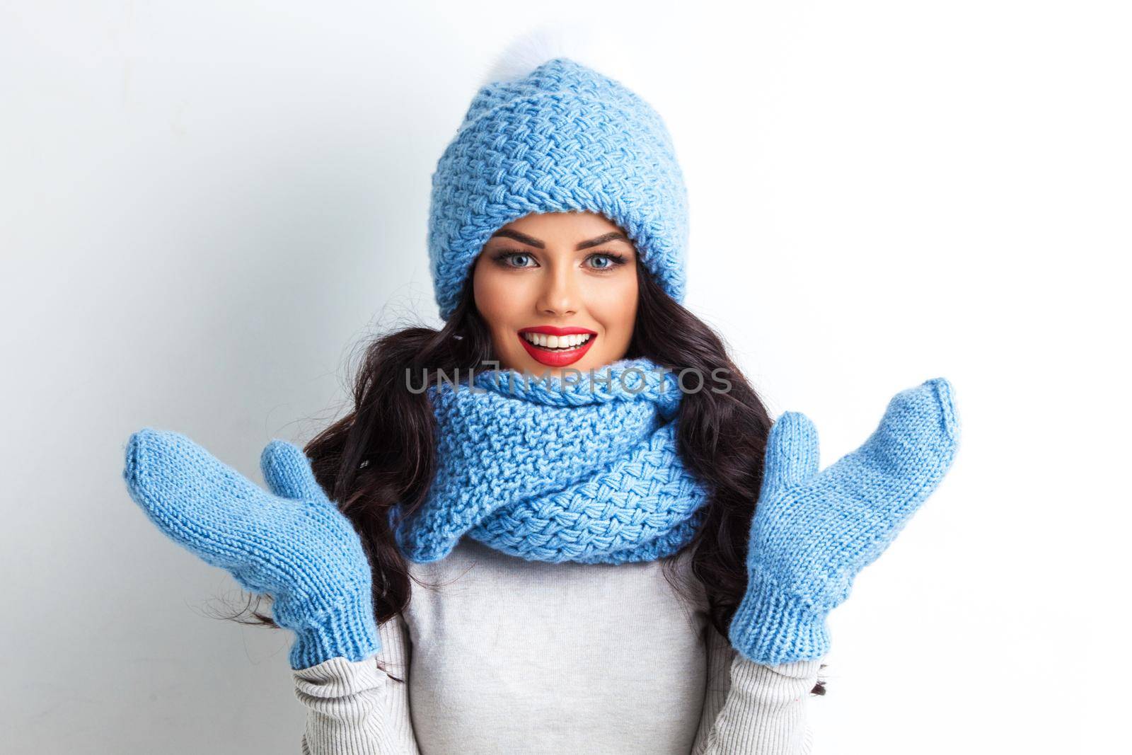Winter, people, happiness concept - woman in hat, muffler and mittens with surprised facial expression