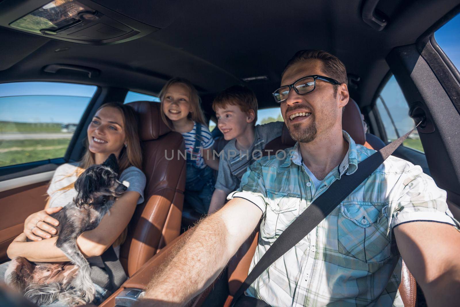 cheerful family with two children goes to the car by asdf