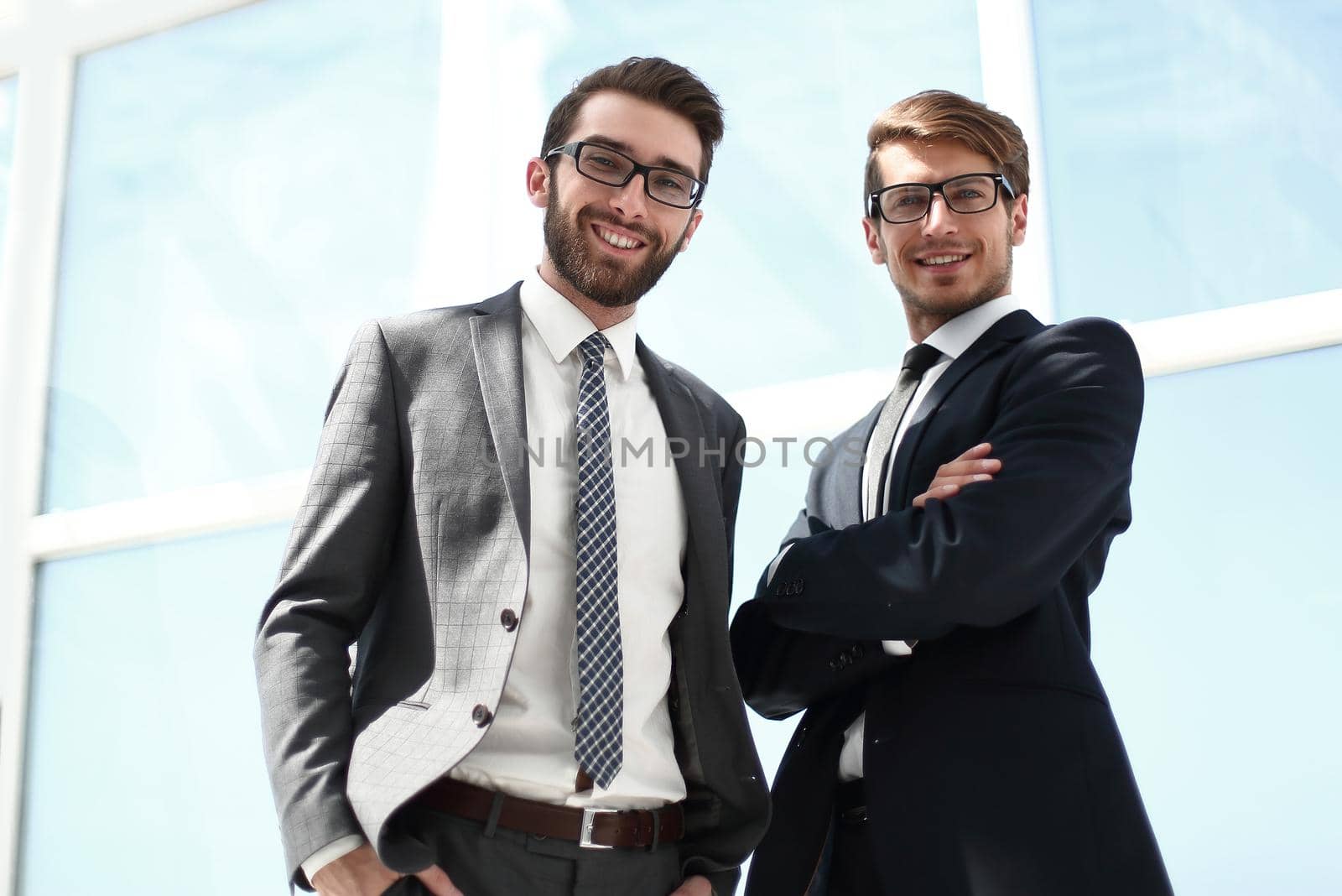 two business partners standing near the office window by asdf