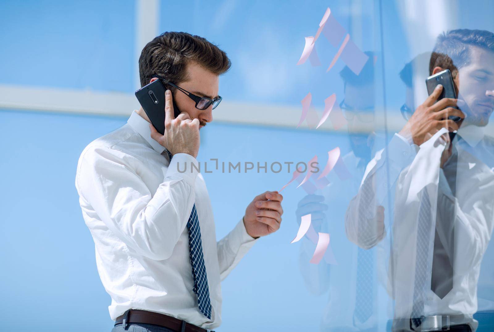 serious businessman talking on smartphone. by asdf