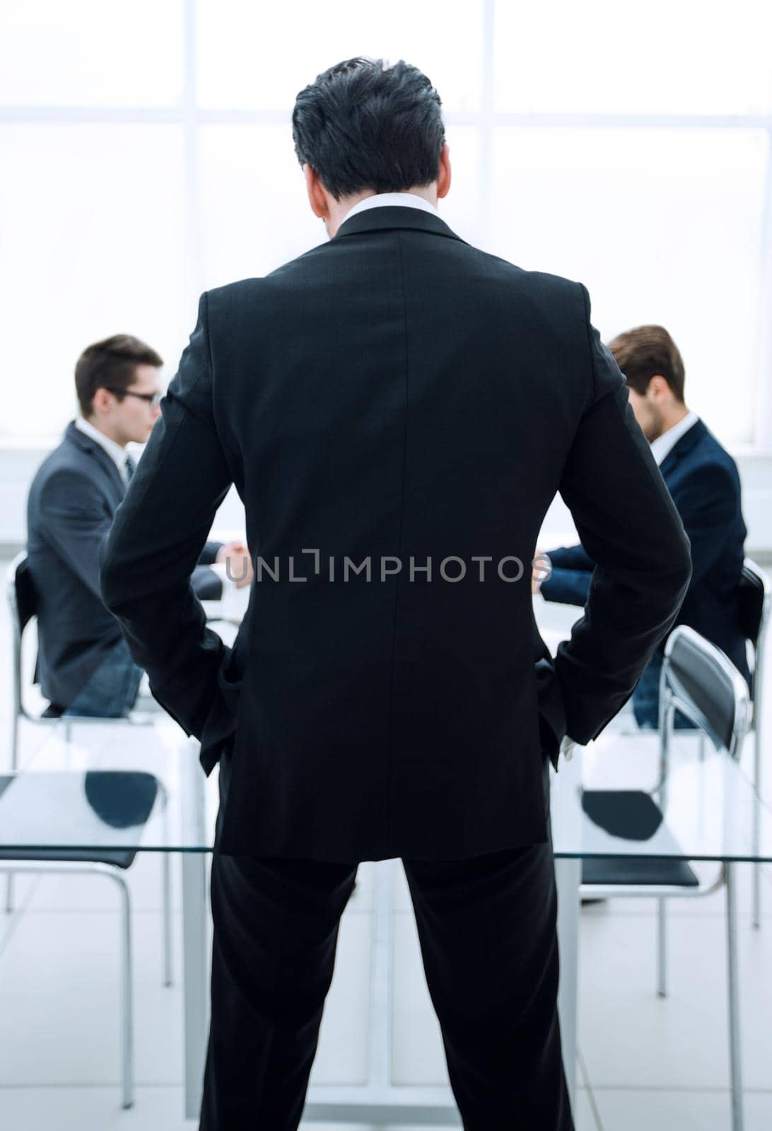 rear view.businessman standing in the conference room by asdf