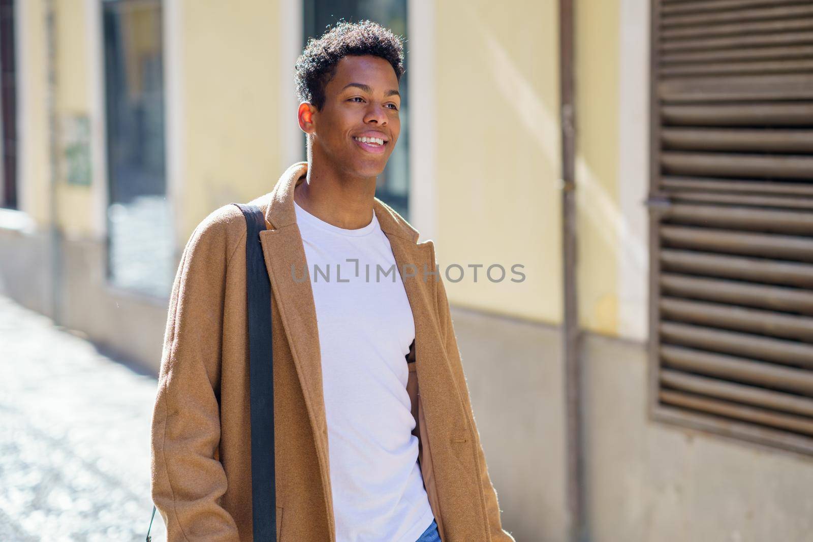 Young Cuban man standing in the street. Student in urban background.