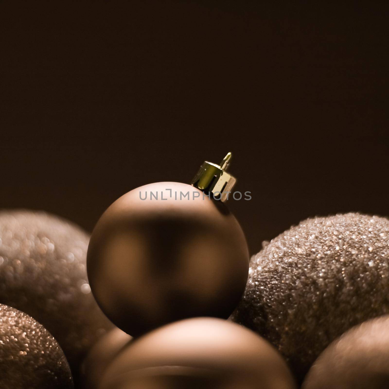 Christmas holiday and festive decoration concept. Golden baubles on beige background.