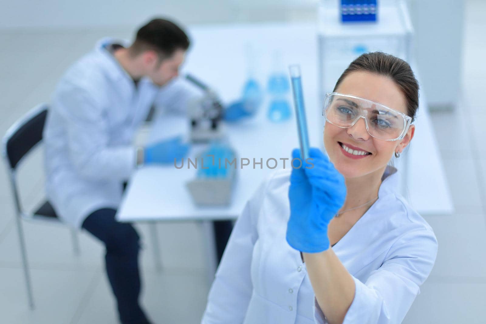smiling woman scientist looking at the tube with the results of the analysis.photo with copy space
