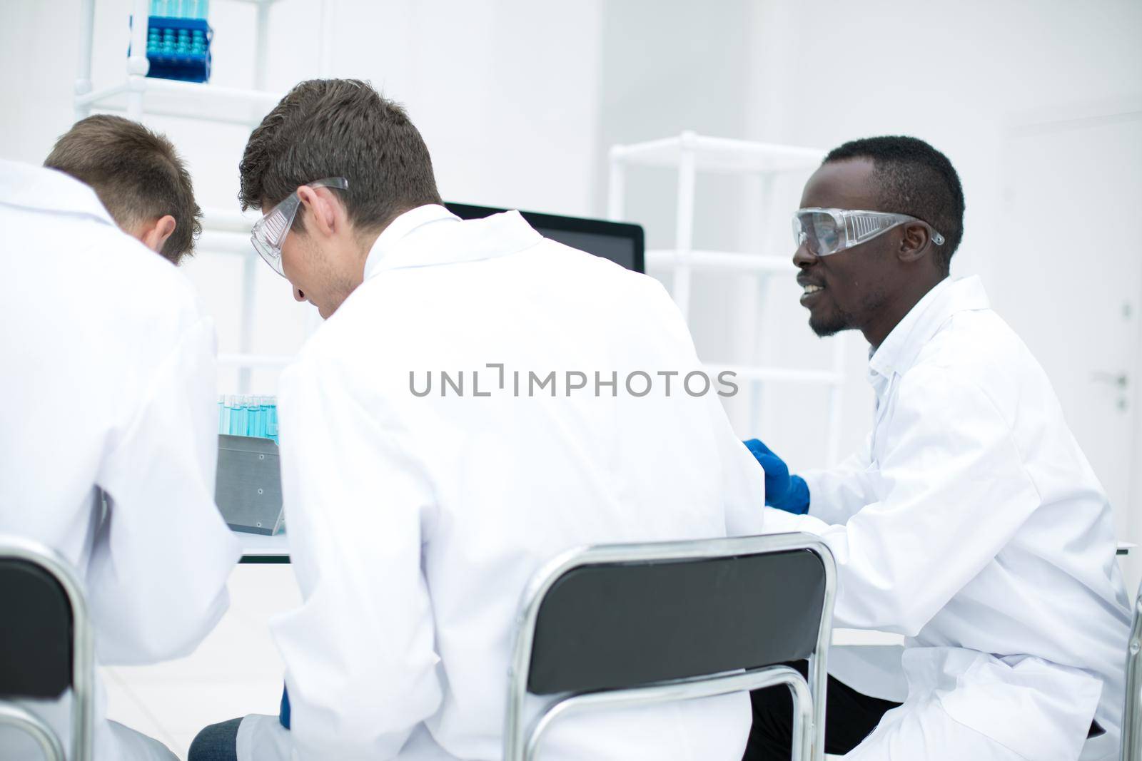 rear view. a group of scientists at the laboratory table by asdf