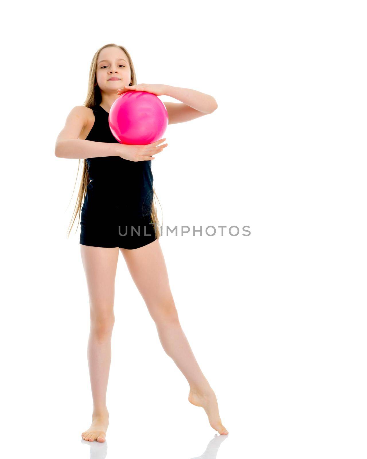 A charming little girl is engaged in fitness with a ball. The concept of gymnastics, health and sports. Isolated on white background.