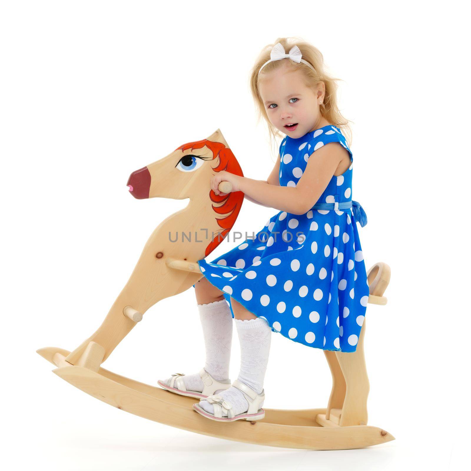 Girl swinging on a wooden horse. by kolesnikov_studio