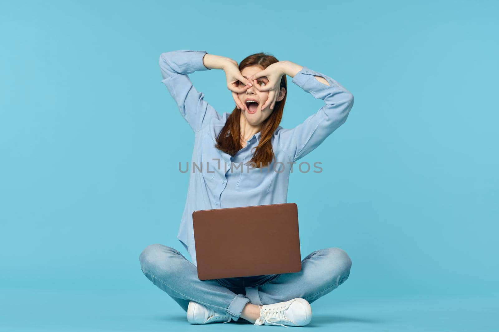 woman student sitting on floor with laptop education blue background. High quality photo