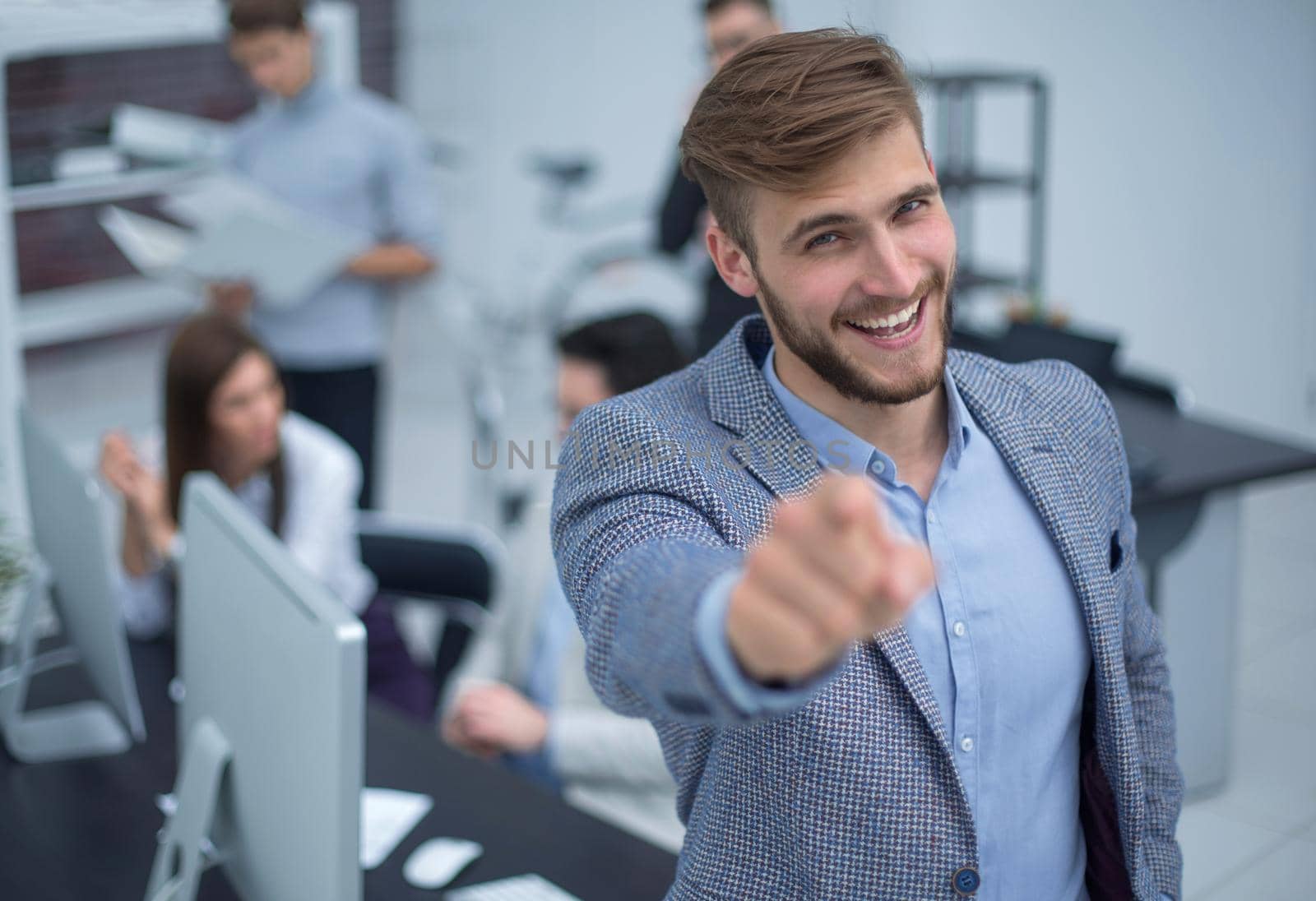 young businessman standing in the office and pointing the finger at you.the concept of choice