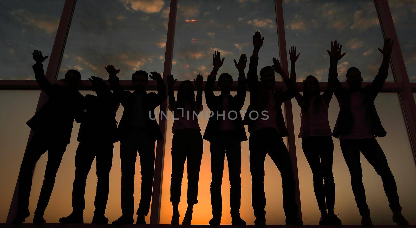 silhouette of a group of business people raising their hands .photo with copy space