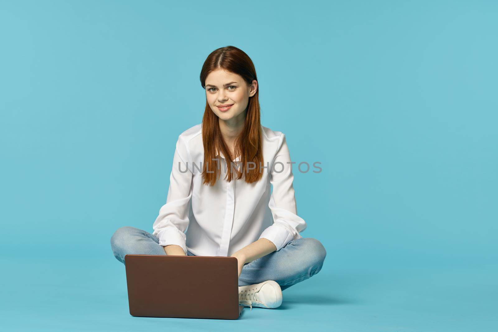 woman with laptop learning internet online education blue background. High quality photo