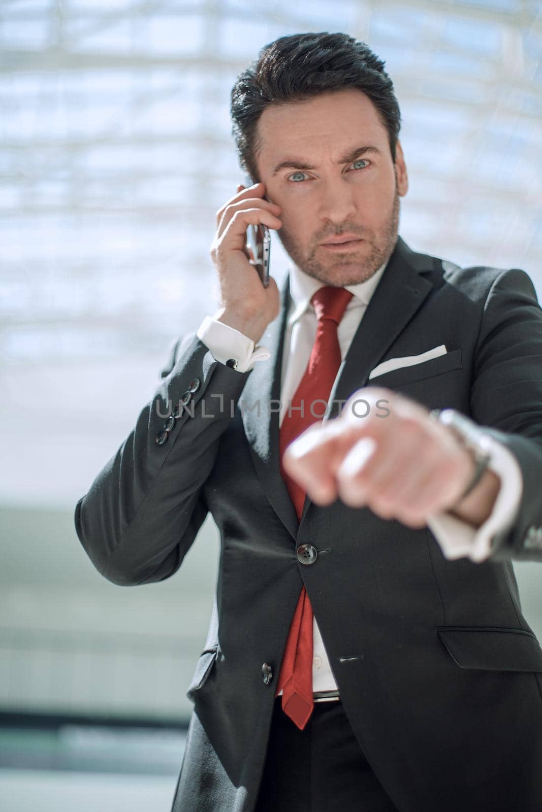 businessman talking on mobile phone and pointing the finger at you.the concept of choice