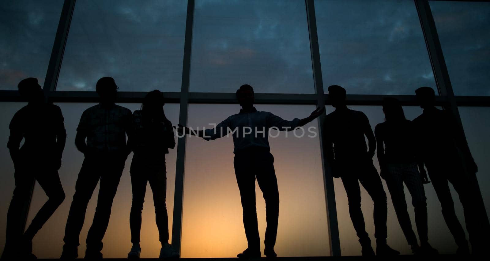 in full growth.the leader and the business team on background of office window