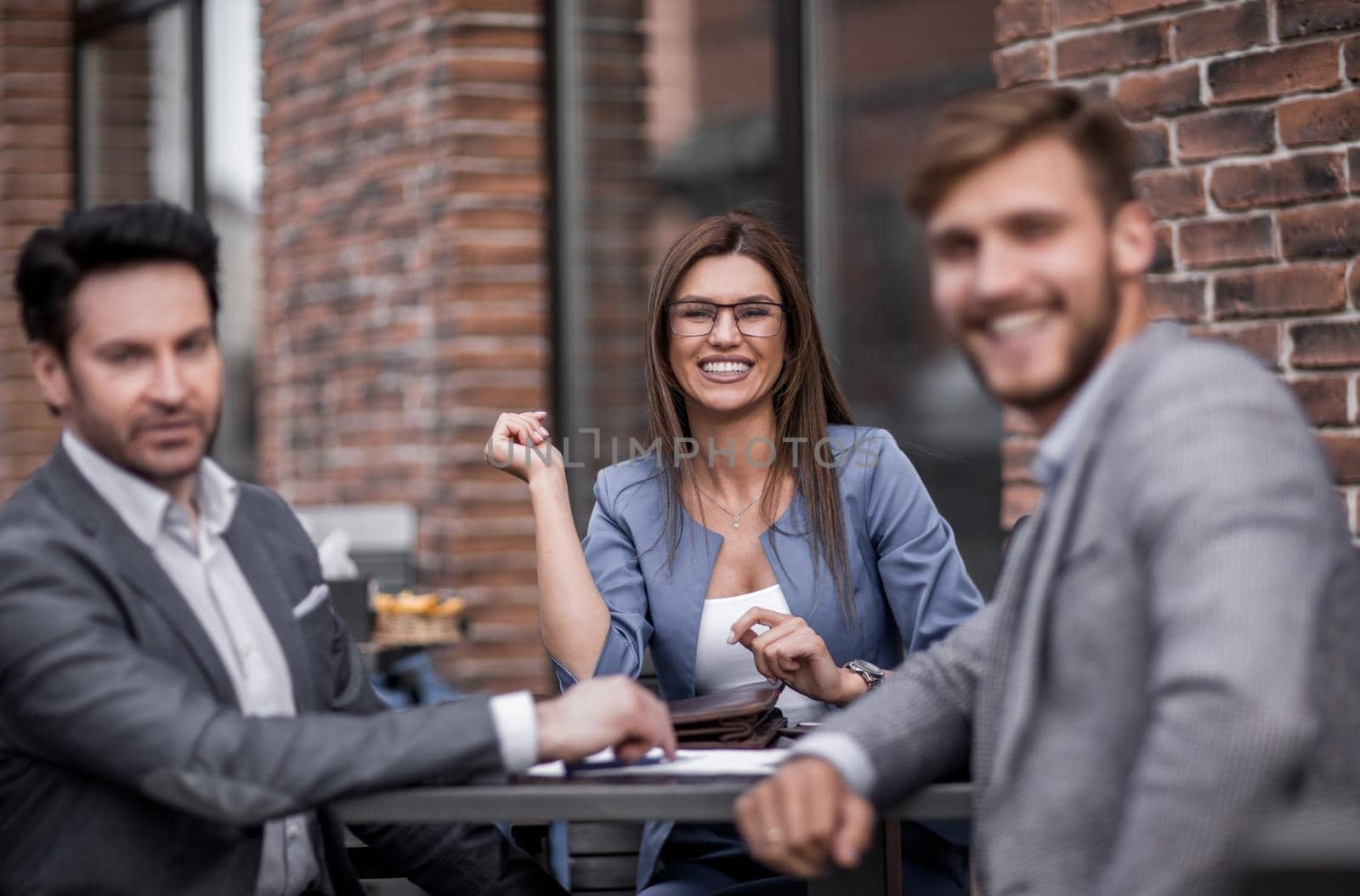 employees of the company sitting at a table in a street cafe.the concept of teamwork