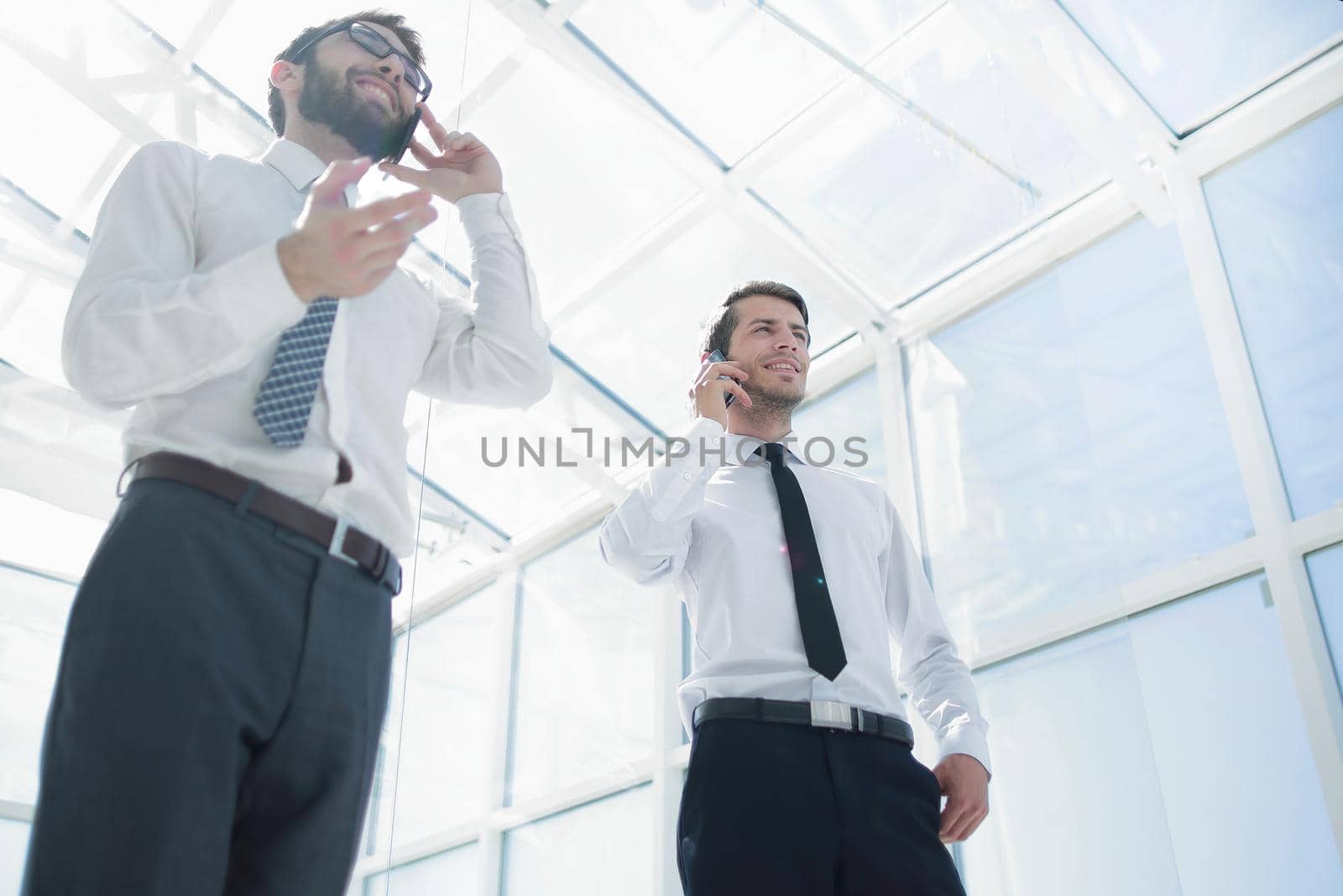 bottom view.two successful businessmen talking on their smartphones.business concept