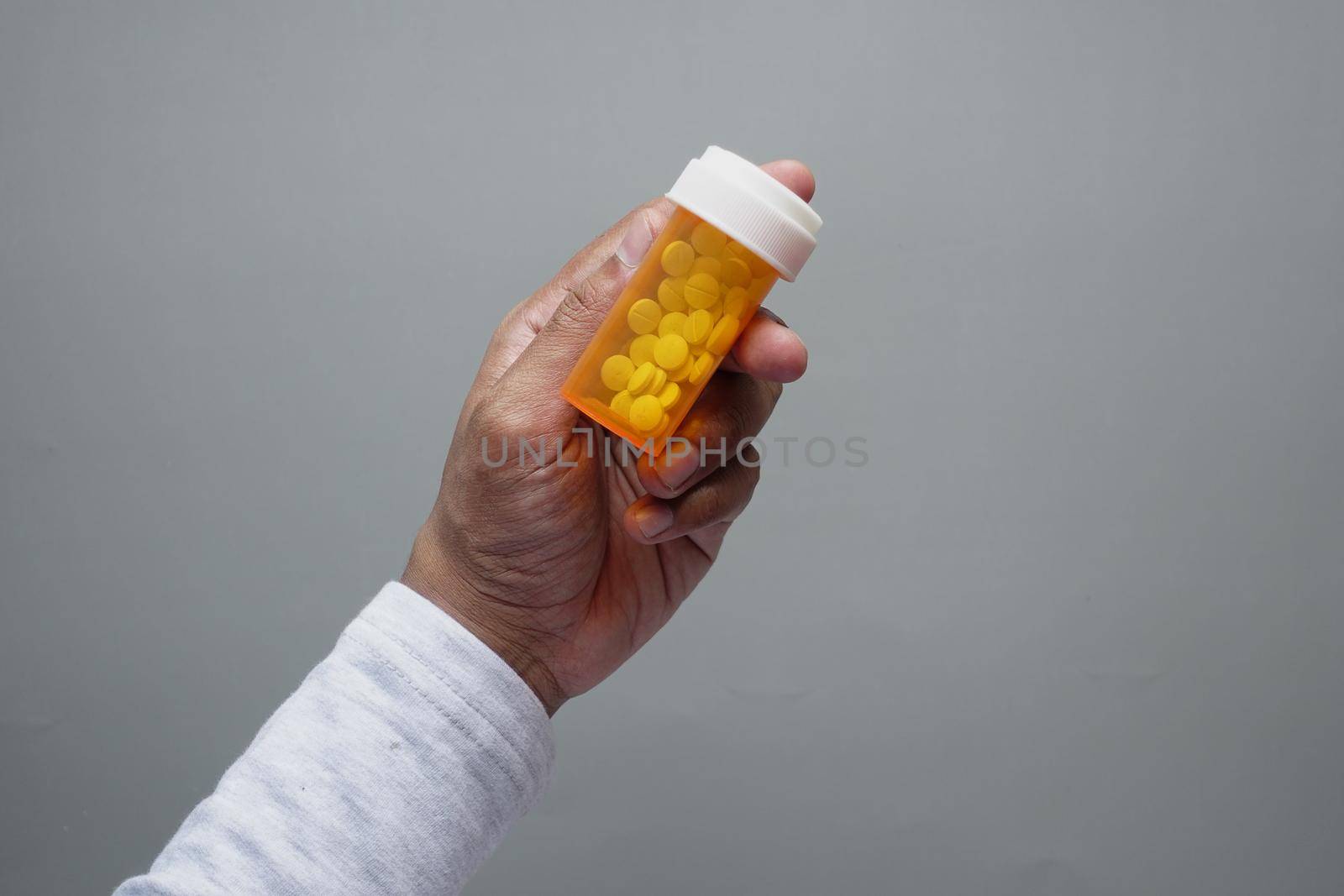 young man hand holding medicine pill container .