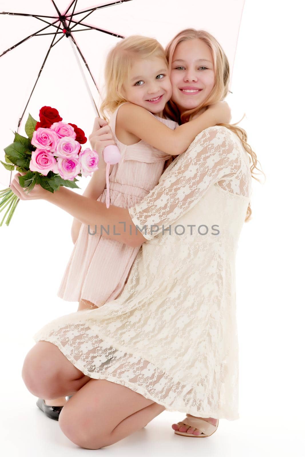 Lovely little girls hid under the umbrella. The concept of a happy childhood, family vacation. Isolated on white background.