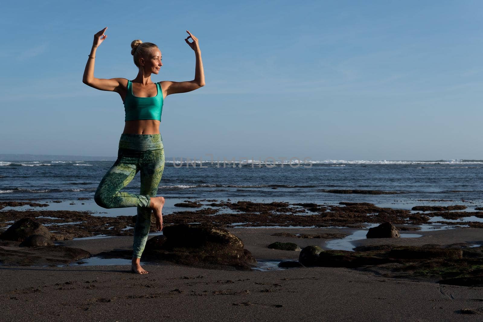 beautiful woman doing yoga on the beach by Alexzhilkin