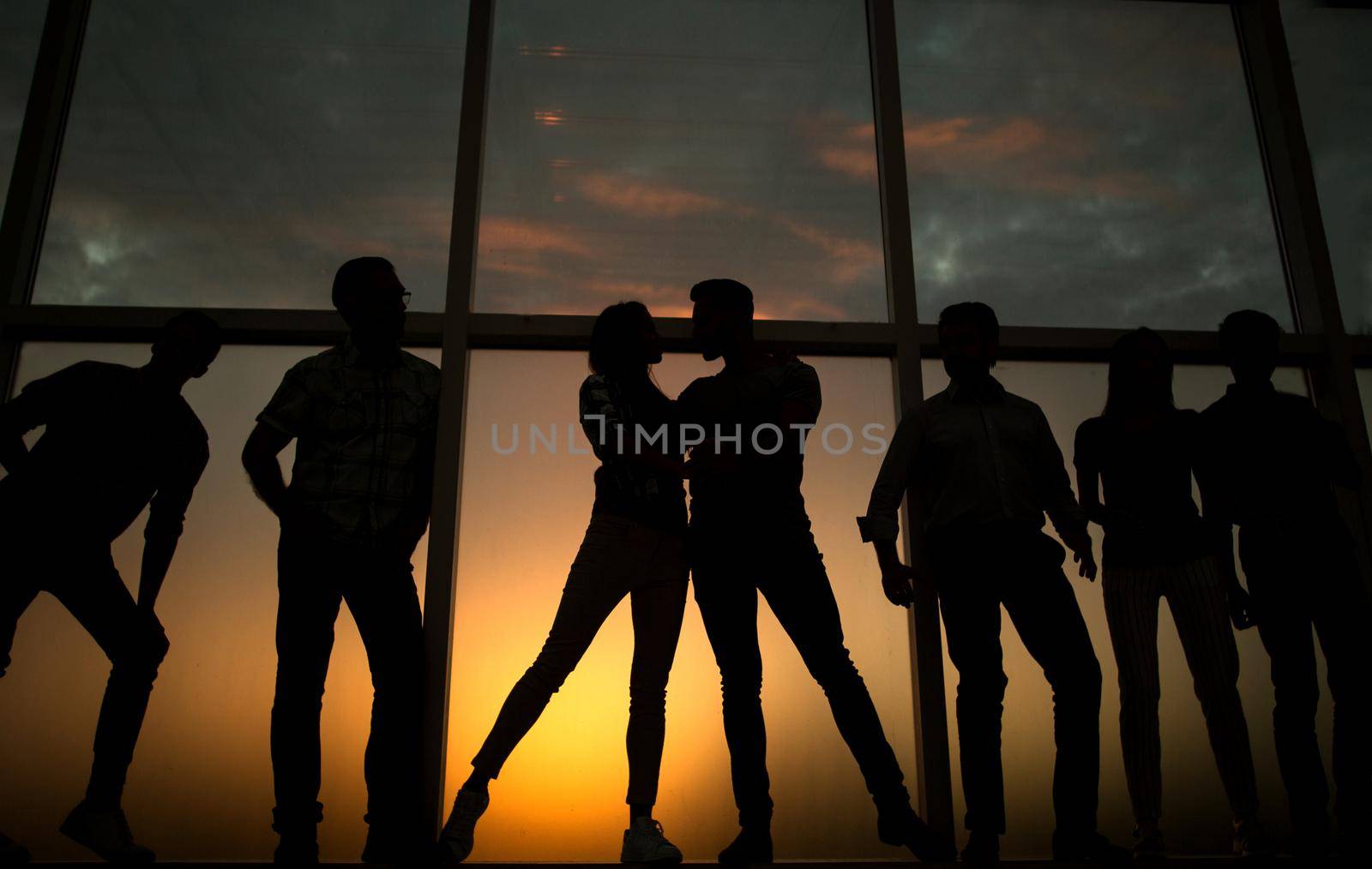 in full growth.a group of young people in the background of a large window