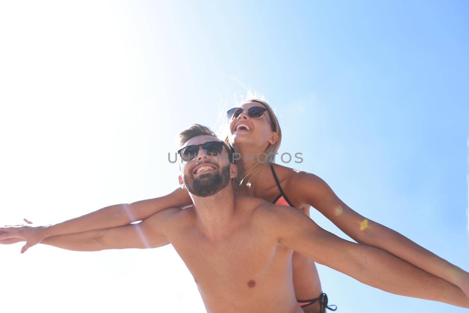 Handsome man giving piggy back to his girlfriend.