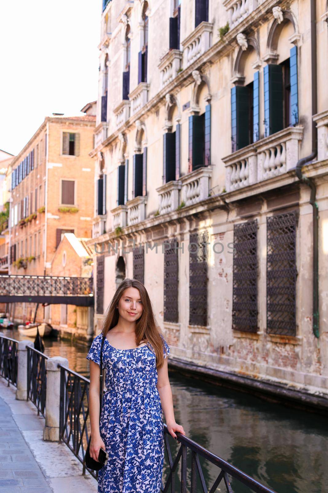 Young woman standing near banister in Venice, Italy. by sisterspro