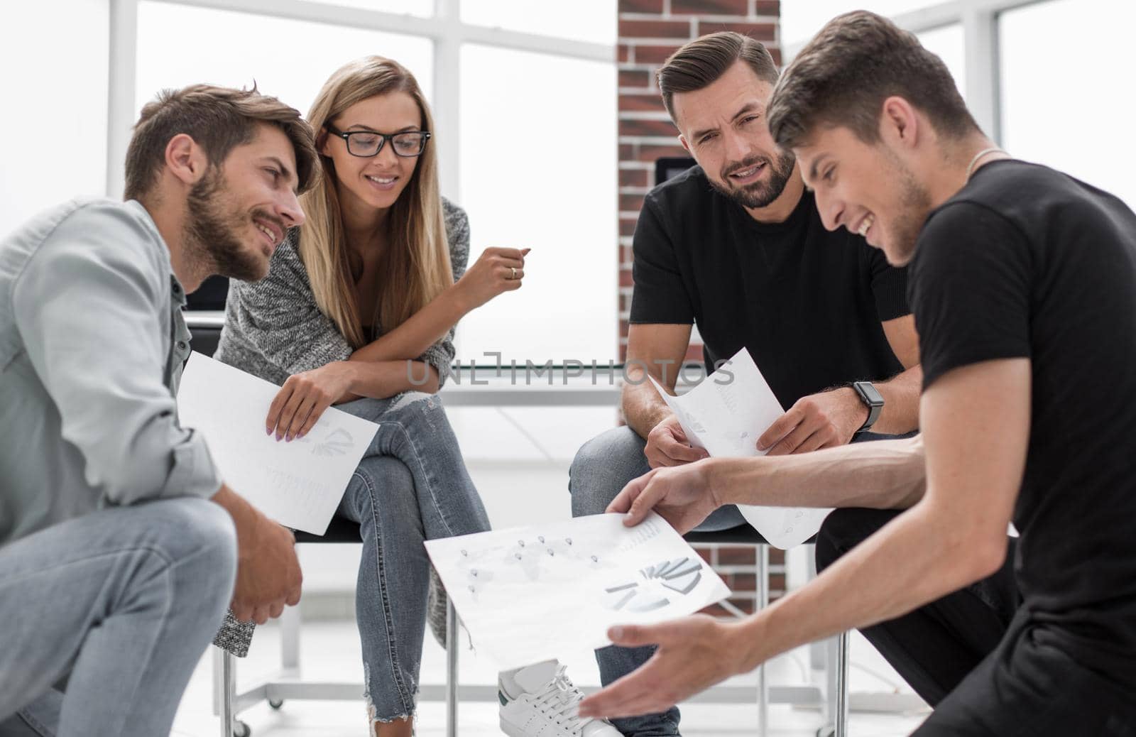 Mens and women sitting together in modern office for project discussion.