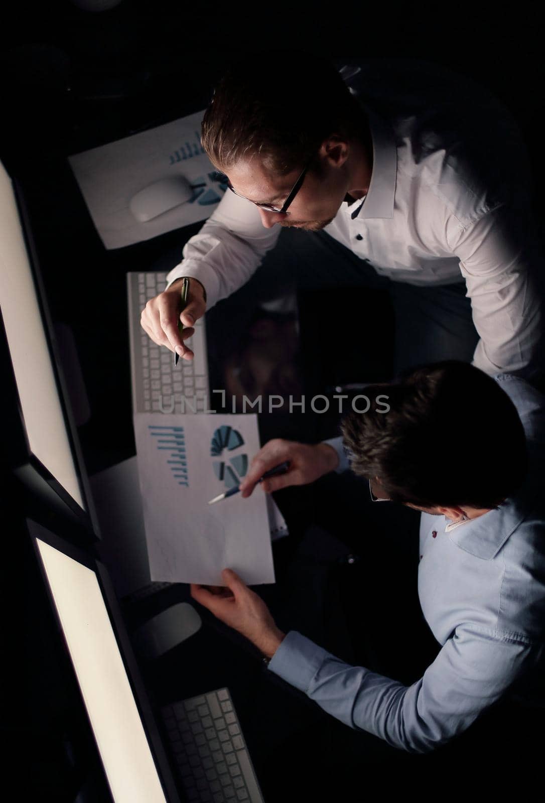top view .two employees analyze the financial chart.the concept of overtime work