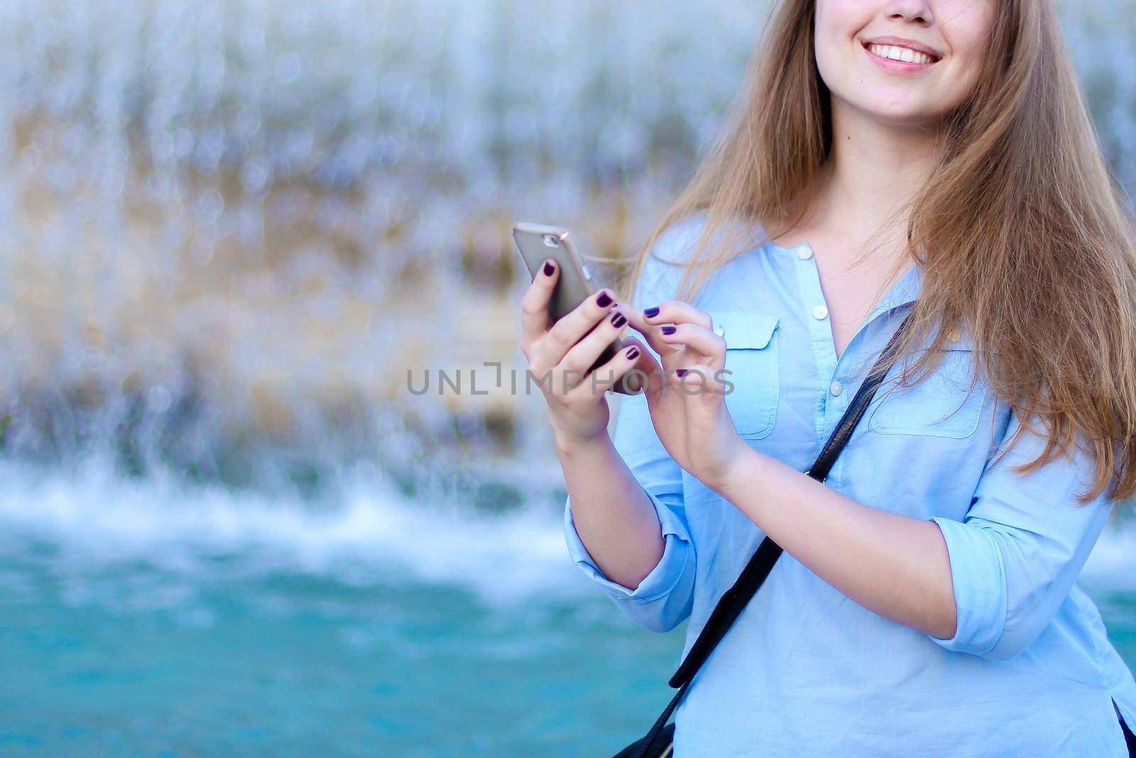 Young woman chatting by smartphone in Trevi fountain background. by sisterspro