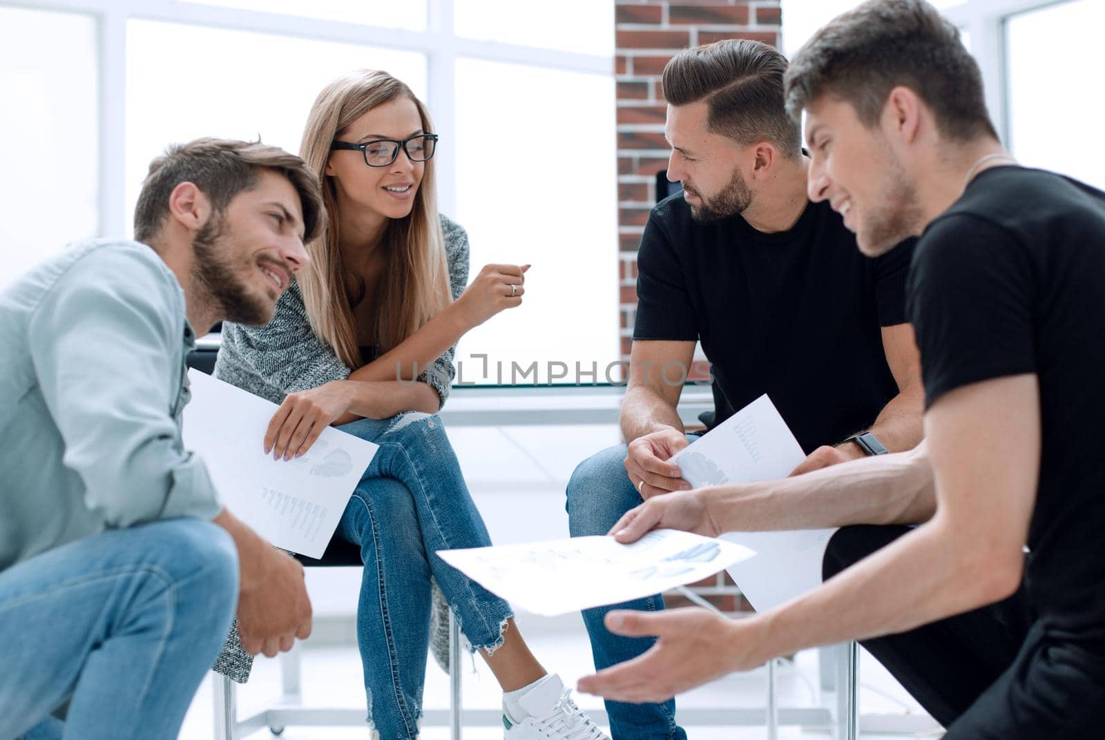 Mens and women sitting together in modern office for project discussion.