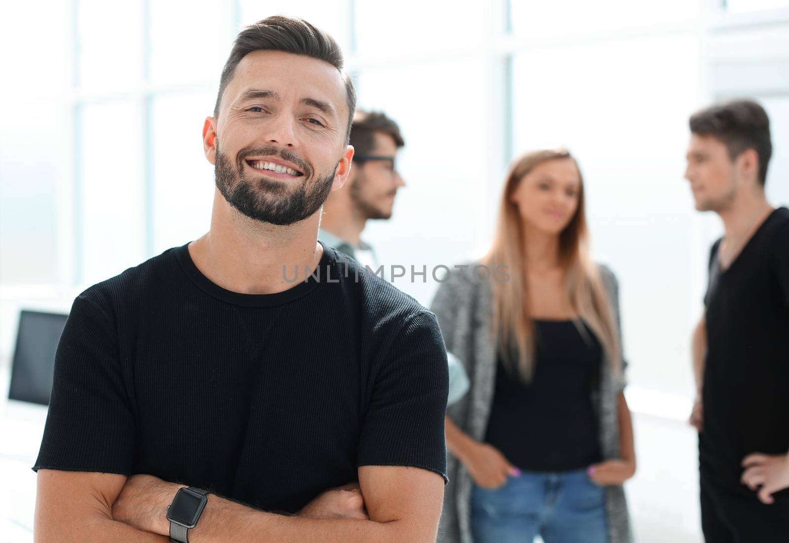 Business - team in an office, the junior manager is standing in front