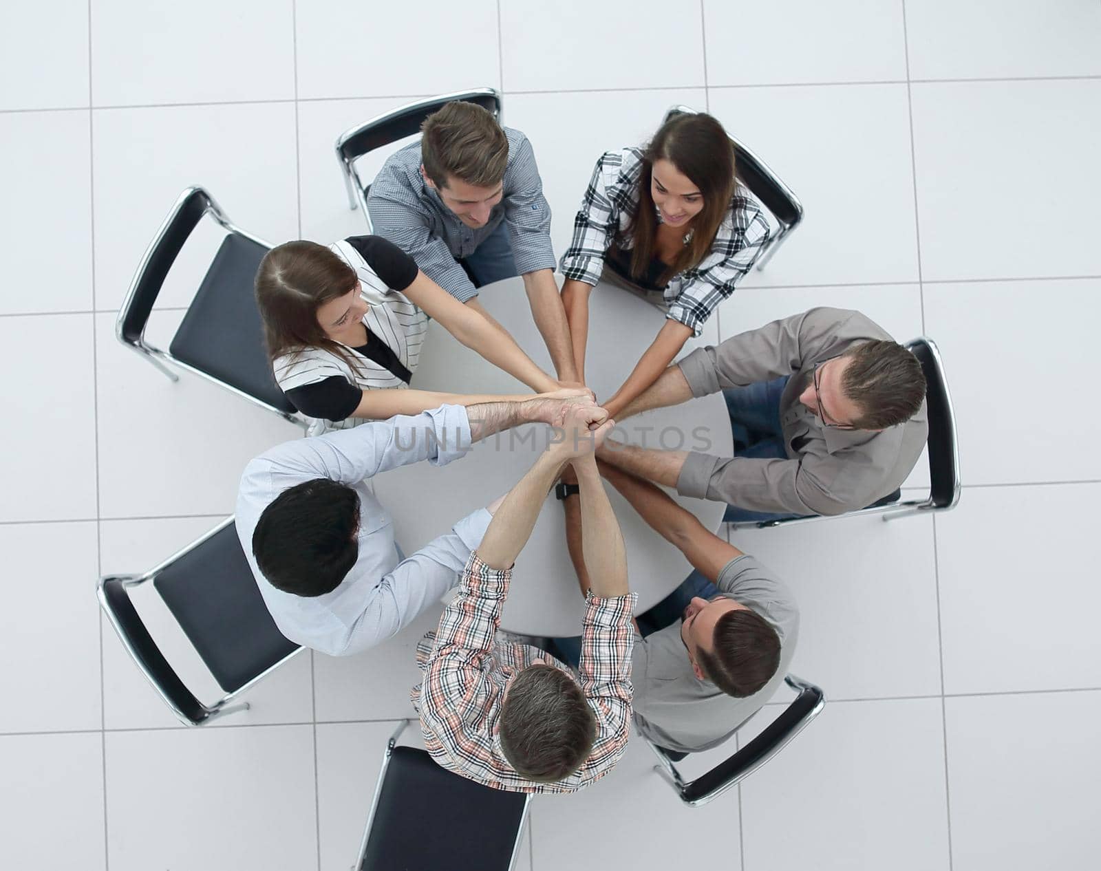 top view.the smiling business team folded their hands together.the concept of teamwork