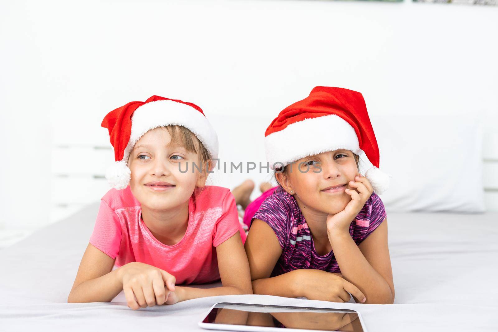 New year concept. christmas, x-mas, winter, happiness concept - two adorable cute girls playing with tablet pc.