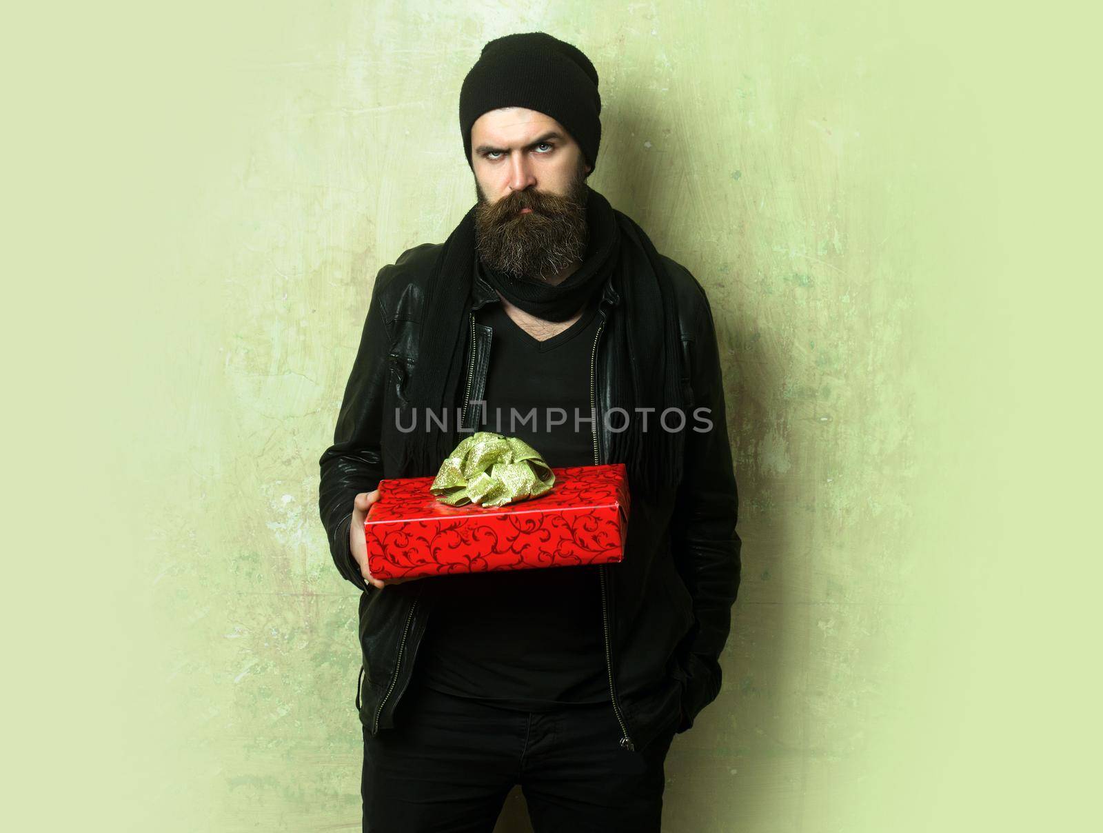 Holiday celebration and shopping. Christmas and birthday. Guy with serious face and gift pack. Hipster with present box.