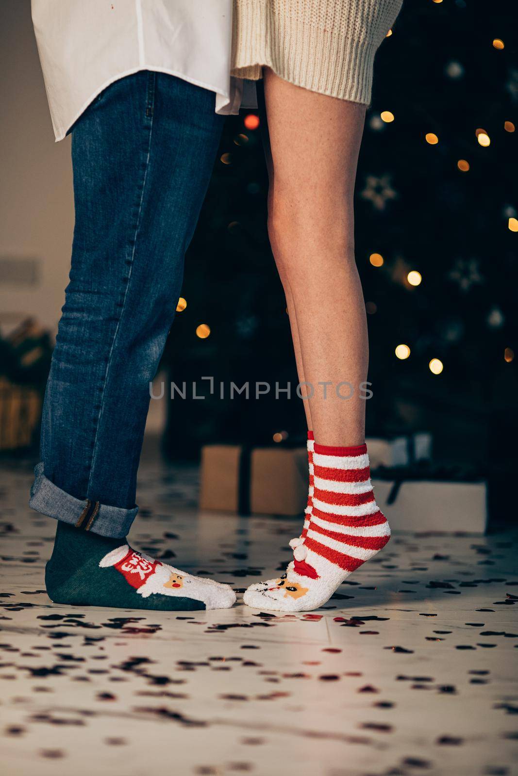 Legs of caucasian girl and her boyfriend in christmas atmosphere