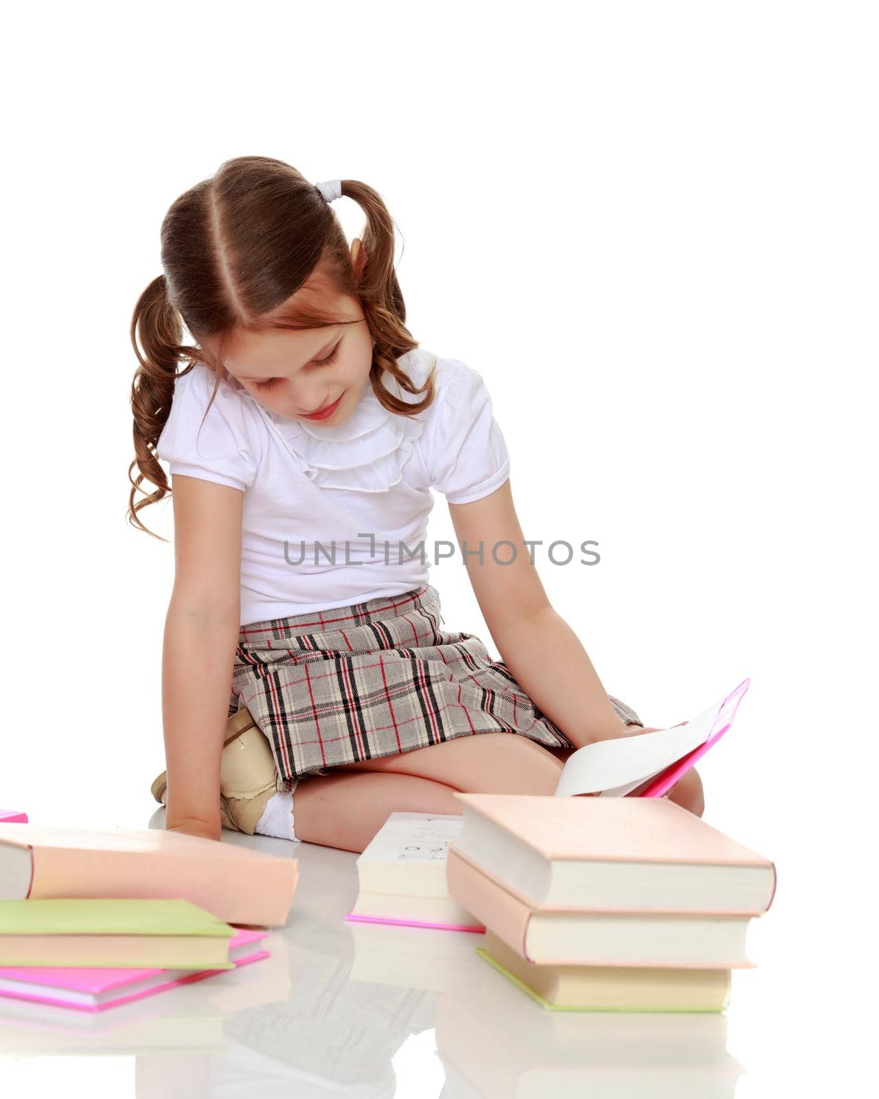 Little girl with book. The concept of education in school or kindergarten. Isolated over white background