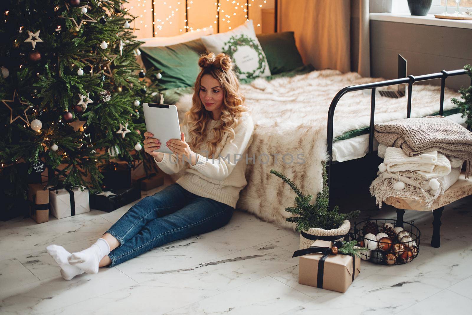 Beautiful caucasian woman wishes happy new year to her family with a tablet