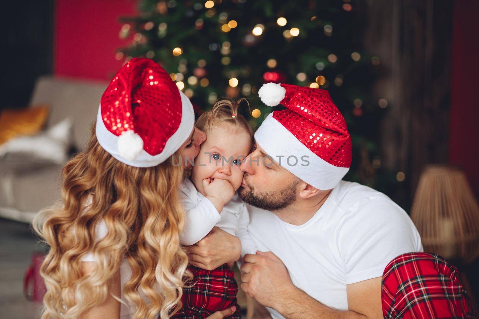 Young family near the christmas tree in the christmas morning by StudioLucky
