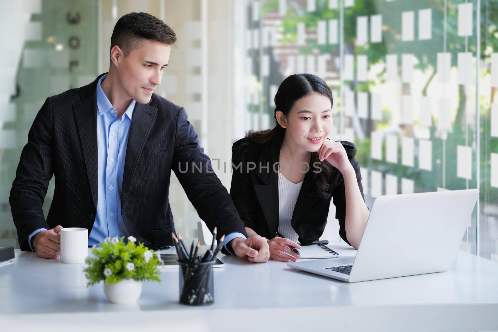 Planning the investment budget, the male advisor is explaining the plan strategy to the female business owner to manage the company's investment budget. by Manastrong