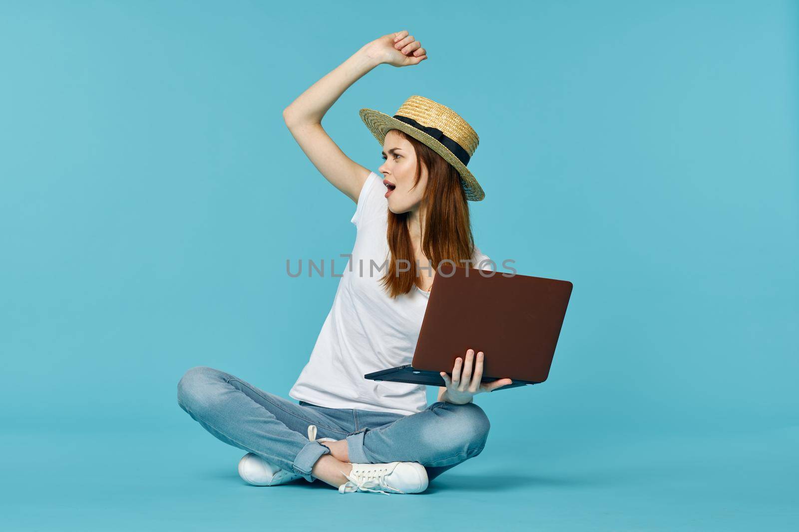 woman with laptop learning internet online education blue background. High quality photo