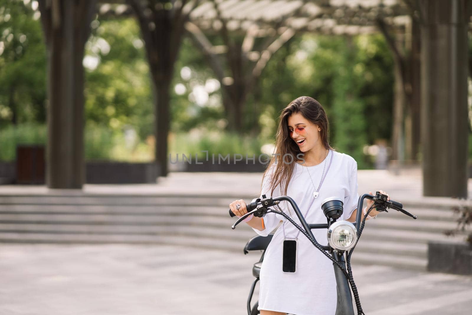 Young beautiful woman and an electric scooter, modern girl, new generation, electric transport, ecological transport