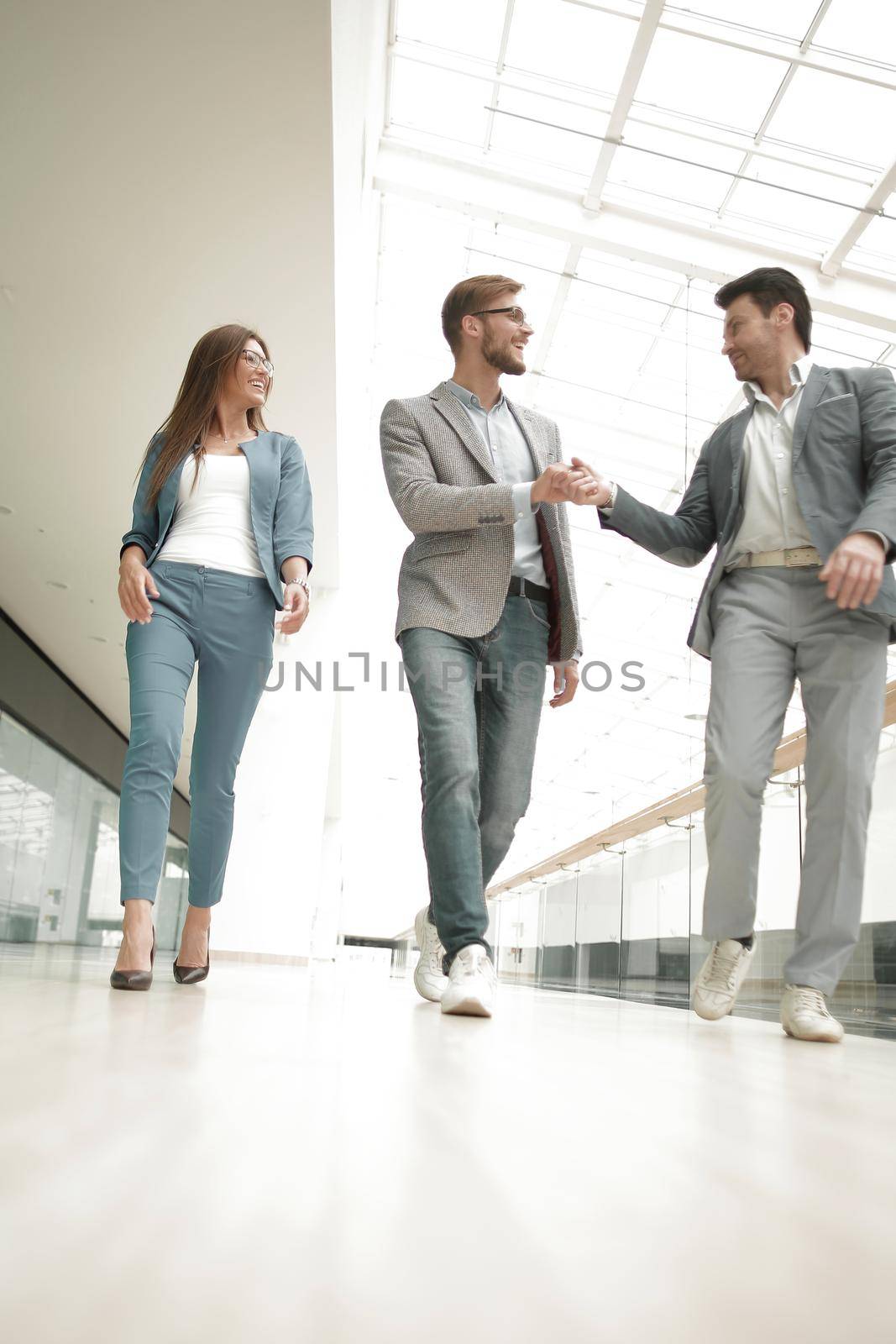 employees greet each other in the office building by asdf